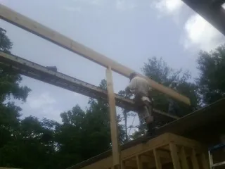 Carpenter setting a ridge beam over a new addition frame — Ice Dam Removal by Roofing Brothers in Trumbull